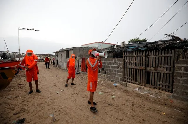 A member of the National Disaster Response Force (NDRF) uses a megaphone to appeal to residents to move to safer place ahead of Cyclone Tauktae in Veraval in the western state of Gujarat, India, May 17, 2021. (Photo by Amit Dave/Reuters)