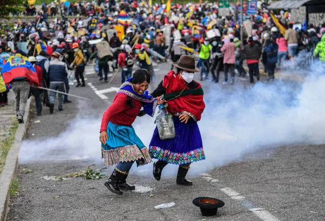 Demonstrators clash with the police in the surroundings of Arbolito Park in Quito on June 23, 2022, in the framework of indigenous-led protests against the government. Indigenous Ecuadoreans have poured into the capital Quito from all over the country to protest high fuel prices and rising living costs, vowing to stay until the government meets their demands, or falls. (Photo by Martin Bernetti/AFP Photo)