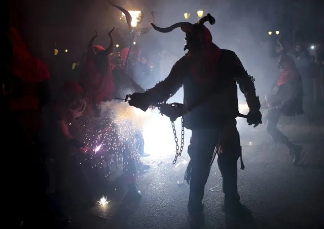 A reveller dressed as a devil holds a stick with fireworks during traditional “Correfocs” (fire runs) to mark the end of the local festivities in Palma, on the Spain's Balearic Island of Mallorca,  January 23, 2016. (Photo by Enrique Calvo/Reuters)