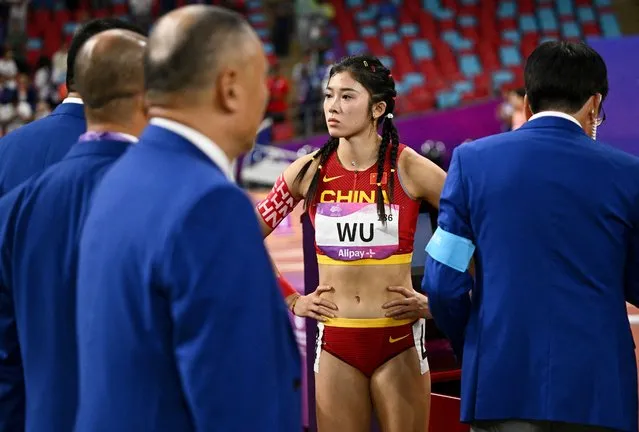 China's Yanni Wu looks on as she stands with officials following a false start during the women's 100m hurdles final at Olympic Sports Centre Stadium in Hangzhou, China on October 1, 2023. (Photo by Dylan Martinez/Reuters)