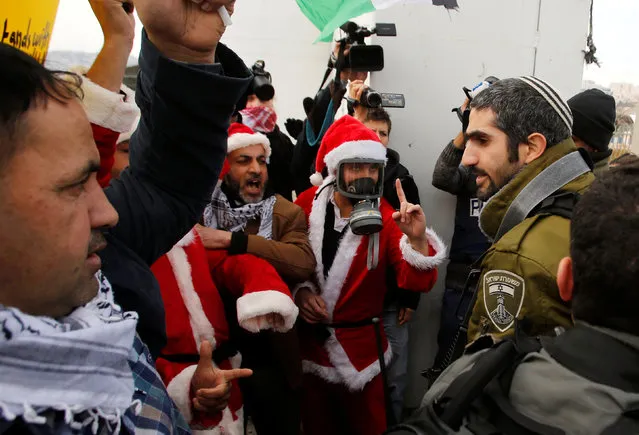 Palestinian protester, dressed as Santa Claus, argues with Israeli troops during clashes at a protest in the West Bank city of Bethlehem, December 23, 2016. (Photo by Mussa Qawasma/Reuters)