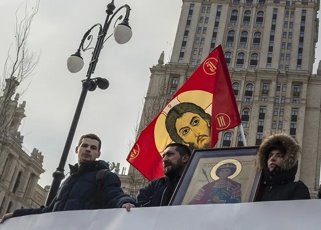 Russian Orthodox Church activists stand in front of Ukraine hotel in a picket to protest the church meeting in Kiev, in Moscow, Russia, Saturday, December 15, 2018. Thousands of people have gathered outside a Kiev cathedral to witness the birth of a new Ukrainian Orthodox Church as tensions between Ukraine and Russia continue to drive the two farther apart. (Photo by Dmitry Serebryakov/AP Photo)