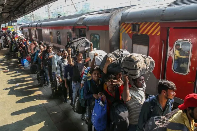 Indian people board a Pawan Express train that will travel through the states of Maharashtra, Madhya Pradesh, Uttar Pradesh and Bihar, ahead of Chhath Puja festival, at Lokmanya Tilak Terminus in Mumbai, India, 15 November 2023. Chhath Puja is a four-day festival devoted to the worship of Surya, the Hindu sun god, also known as Surya Shashti. It is celebrated this year from 17 to 20 November. The festival aims to promote well-being, prosperity, and progress by worshiping the sun, considered the god of energy and life force. It is mainly celebrated in the states of Bihar, Jharkhand, and Uttar Pradesh. (Photo by Divyakant Solanki/EPA)