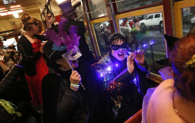 Members of the “Societe des Champs Elysee” ride the Rampart-St. Claude street car line, which just opened last fall, to commemorate the official start of Mardi Gras season, in New Orleans, Friday, January 6, 2017. (Photo by Gerald Herbert/AP Photo)