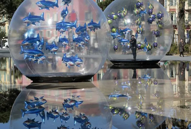 A man installs fish-shaped balloons in a water fountain to mark April Fools' Day, called “Poisson d'Avril” in France, in the centre of Nice, April 1, 2015. (Photo by Eric Gaillard/Reuters)