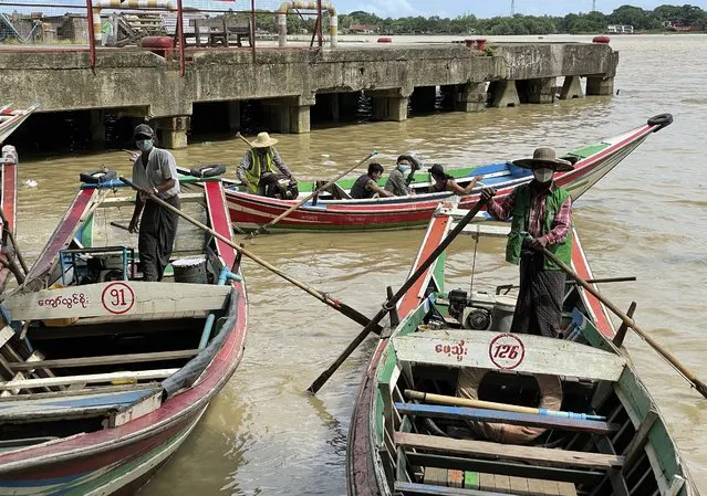 Boatmen wearing face masks wait for passengers at the jetty in Yangon, Myanmar, Thursday, July 8, 2021. (Photo by AP Photo/Stringer)