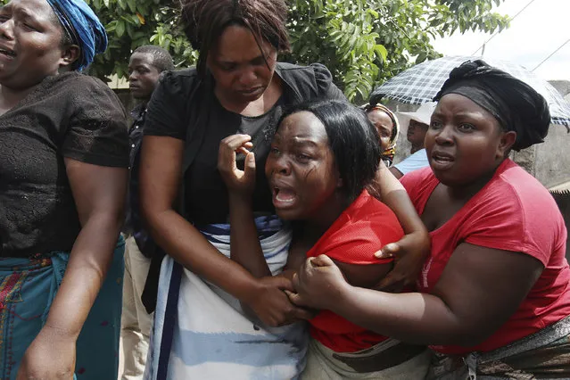 A family member of Kelvin Tinashe Choto reacts, during his funeral in Chitungwiza, about 30 kilometres south east of the capital, Harare, Zimbabwe, Saturday, January 19, 2019. Before the family of Kelvin Tinashe Choto knew he had been killed, social media in Zimbabwe was circulating a photo of his battered body lying on the reception counter of a local police station. Angry protesters had left him there. The 22-year-old was shot in the head, one of at least a dozen people killed since Monday in a violent crackdown by security. (Photo by Tsvangirayi Mukwazhi/AP Photo)
