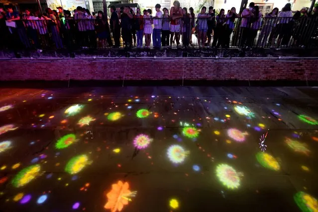Lights are projected on a canal during a Loy Krathong celebration to encourage people to use digital krathongs instead of traditional ones, to reduce waste, in Bangkok, Thailand on November 27, 2023. (Photo by Thomas Suen/Reuters)