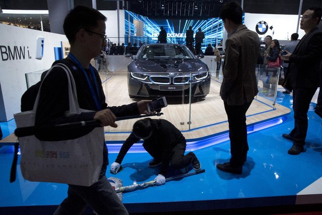Attendees look at the latest car from BMW at the Shanghai Auto Show in Shanghai, Monday, April 20, 2015. (Photo by Ng Han Guan/AP Photo)