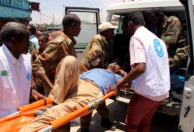 A man wounded from the ongoing violence in Yemen is helped into an ambulance on arrival at the port of Bosasso in Somalia's Puntland region, April 26, 2015. (Photo by Abdiqani Hassan/Reuters)