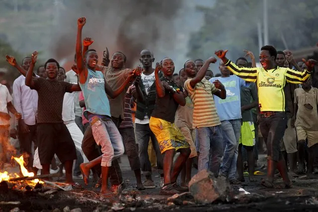 Protestors chant anti-government slogans as they clash with riot police during a protest against the ruling CNDD-FDD party's decision to allow President Pierre Nkurunziza to run for a third five-year term in office, in the capital Bujumbura, April 27, 2015. (Photo by Thomas Mukoya/Reuters)