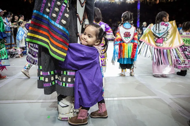 Peyton Moses, 18 months, clings to her mom, Heather Blackgoat, from Kirtland, N.M., before the Tiny Tot Girls competition in the 32nd annual Gathering of Nations in Albuquerque N.M., Saturday, April 25, 2015. (Photo by Mark Holm/AP Photo)