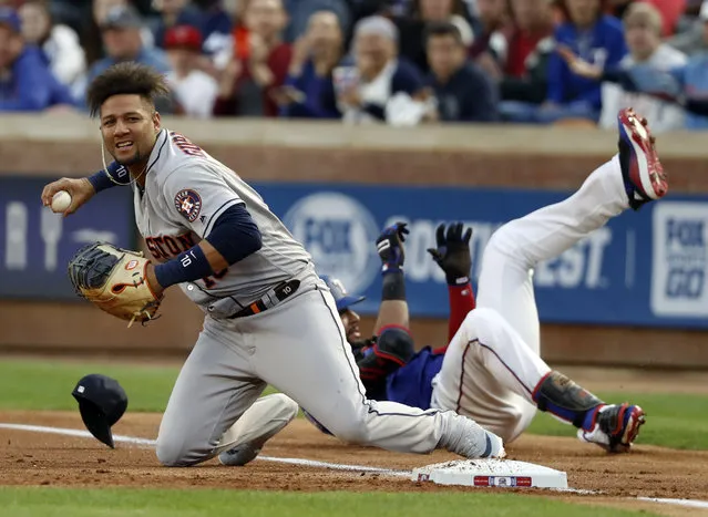 Houston Astros first baseman Yuli Gurriel (10) prepares to throw home after a collision with Texas Rangers' Nomar Mazara during the first inning of a baseball game in Arlington, Texas, Wednesday, April 3, 2019. Mazara was safe at first on the play with a single that scored Elvis Andrus. (Photo by Tony Gutierrez/AP Photo)
