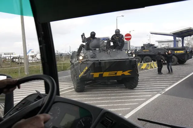 Counter Terrorism Centre (TEK) personnel arrive with an APC vehicle at the parking facility of the Liszt Ferenc International Airport in Budapest, Hungary, Tuesday, March 22, 2016. Hungary raised its terrorism awareness level to grade 2 after a series of attacks in Brussels. (Photo by Zsolt Szigetvary/MTI via AP Photo)
