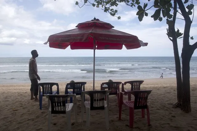 A beach vendor sets chairs as he waits for customers in Kuta beach in Bali, Indonesia, Thursday, October 14, 2021. The Indonesian resort island of Bali welcomed international travelers to its shops and white-sand beaches for the first time in more than a year Thursday – if they're vaccinated, test negative, hail from certain countries, quarantine and heed restrictions in public. (Photo by Firdia Lisnawati/AP Photo)