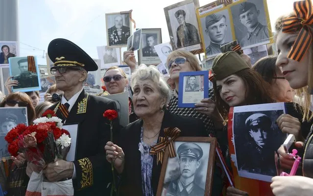 People take part in Immortal Regiment march with pictures of World War Two soldiers on Red Square during the Victory Day celebrations in Moscow, Russia, May 9, 2015. (Photo by Reuters/Host Photo Agency/RIA Novosti)