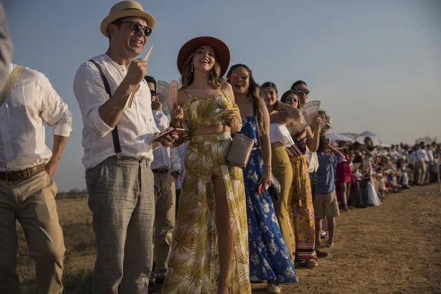 In this February 16, 2019 photo, guests wait for groom Juan Jose Pocaterra and bride Maria Fernanda Vera to arrive to their destination wedding in Acarigua, Venezuela. The wedding guests included wealthy landowners, opposition politicians and a former student leader who nearly lost an eye during an anti-government protest. (Photo by Rodrigo Abd/AP Photo)