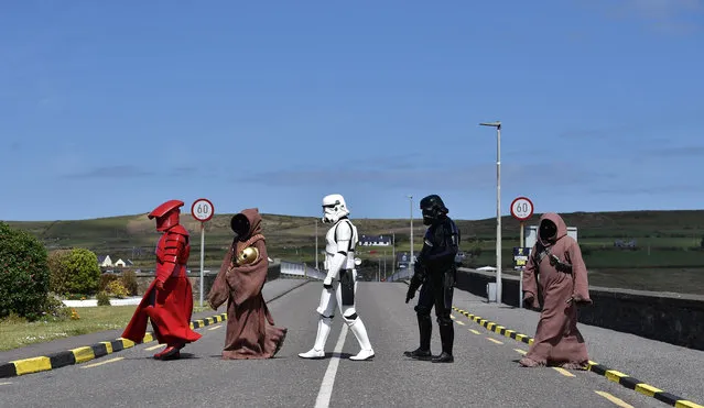 Members of the 501st Garrison Ireland Legion cross the bridge as they patrol the small fishing village on May 5, 2019 in Portmagee, Ireland. The latest Star Wars movies such as The Last Jedi have featured the famous Skellig Michael islands situated off the coast of the small Irish fishing village. The May the Fourth Star Wars festival is taking place this weekend in the small County Kerry village for the second year running as millions of fans worldwide celebrate the science fiction series. The quiet coastal setting has seen a sharp rise in the number of tourists and fans visiting the area. (Photo by Charles McQuillan/Getty Images)