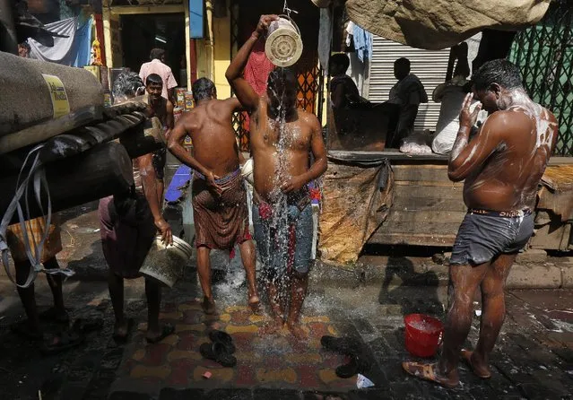 Men bath at a roadside municipal tap at a wholesale market area in Kolkata, India, March 22, 2016. (Photo by Rupak De Chowdhuri/Reuters)