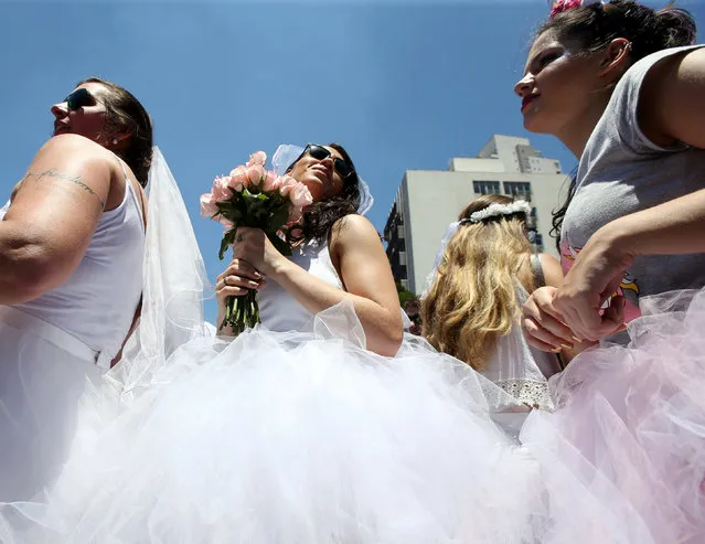 Revellers take part in the annual “Marry me” carnival block parade in the main street in Sao Paulo, Brazil February 18, 2017. (Photo by Paulo Whitaker/Reuters)