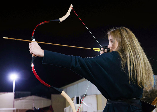 A Palestinian girl aims her bow during an archery class, using locally handmade bows and arrows, at the Friends Club in Gaza City on November 16, 2021. (Photo by Mahmud Hams/AFP Photo)