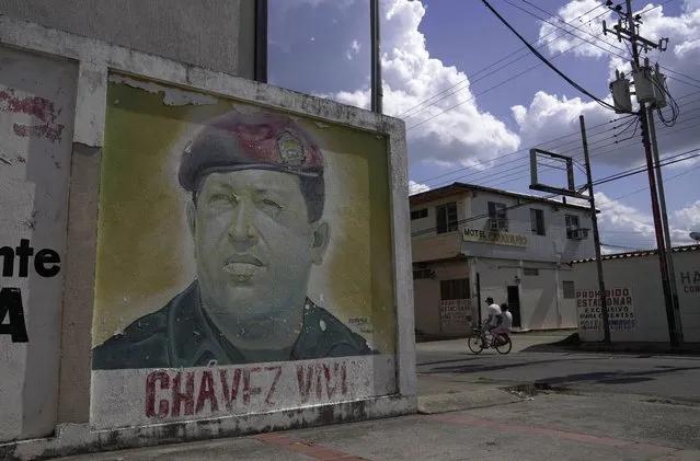A mural depicting late Venezuelan president Hugo Chavez adorns a wall at his home town Sabaneta, in Barinas state in Venezuela, Sunday, December 5, 2021. Venezuelan President Nicolas Maduro named Former foreign minister Jorge Arreaza via a livestream as the ruling party's candidate to the gubernatorial race for Barinas State. The announcement came less than a week after the country's highest court disqualified opposition candidate Freddy Superlano for the governorship of Barinas as he was leading the vote count, a move that has become emblematic of what the opposition says are unfair election conditions. (Photo by Ariana Cubillos/AP Photo)