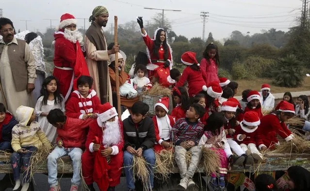 Christians, some wearing Santa Claus suits, participate in a Christmas celebration rally in Lahore, Pakistan, Sunday, December 19, 2021. (Photo by K.M. Chaudary/AP Photo)