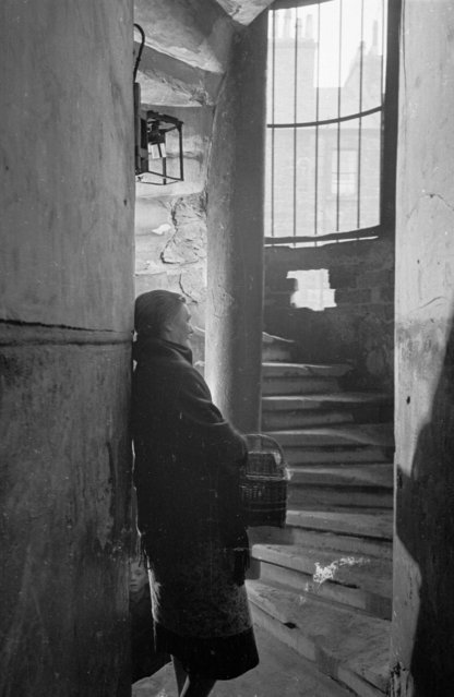 A woman standing at the bottom of a flight of stairs in the Gorbals area of Glasgow on January 31, 1948. (Photo by Bert Hardy/Picture Post/Getty Images)