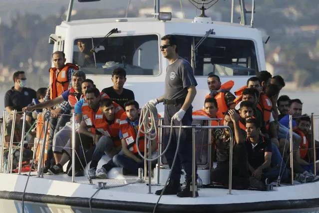 A Greek Coast Guard vessel arrives with migrants after an operation at the port of Mitylene on the northeast Greek island of Lesvos Wednesday, June 17, 2015. Around 100,000 migrants have entered Europe so far this year as Italy and Greece have borne the brunt of the surge with many more migrants expected to arrive from June through to September. (AP Photo/Thanassis Stavrakis)
