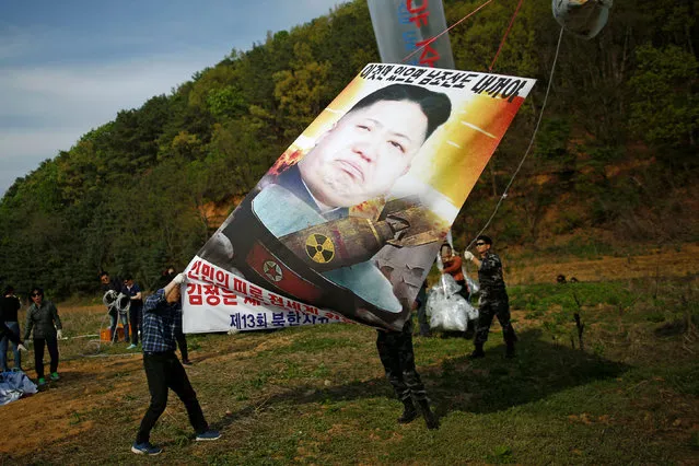 Park Sang-hak (L), a North Korean defector and leader of an anti-North Korea civic group, holds a banner depicting North Korean leader Kim Jong Un with nuclear, tied on a balloon, near the demilitarized zone in Paju, South Korea, April 29, 2016. (Photo by Kim Hong-Ji/Reuters)