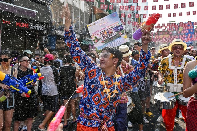 Revellers take part in mass water fights on the eve of Songkran, or Thai New Year, on Khao San Road in Bangkok on April 12, 2024. (Photo by Lillian Suwanrumpha/AFP Photo)
