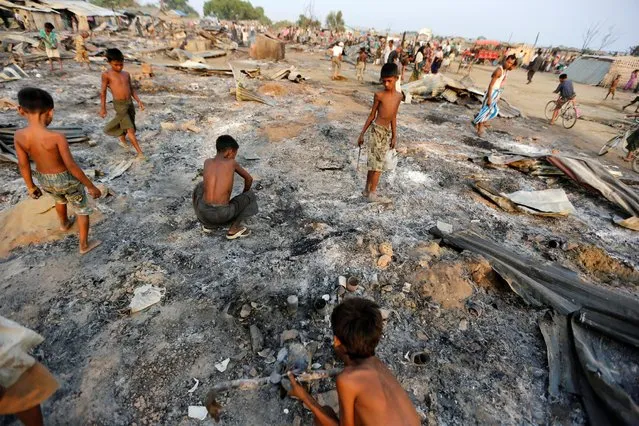 Boys search for useful items among the ashes of burnt houses after fire destroyed shelters at a camp for internally displaced Rohingya Muslims in the western Rakhine State near Sittwe, Myanmar May 3, 2016. (Photo by Soe Zeya Tun/Reuters)