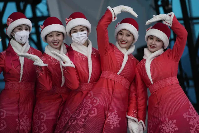 Hostesses stand for a photograph before a medal ceremony at the 2022 Winter Olympics, Saturday, February 19, 2022, in Beijing. (Photo by Jae C. Hong/AP Photo)