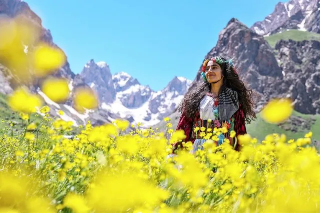 A woman wearing local clothes poses for a photo at Mount Cilo in Turkey's Eastern Anatolian province Hakkari on June 09, 2021. Cilo Mountains located on Ikiyaka mountains declared “National Park” is one of the natural beauty spots for travelers in Hakkari's Yuksekova district. 27,500 hectares of national park area draws attention coexisting four seasons with colorful flowers and snow on top of hills. Uludoruk, the second highest mountain in Turkey, located on Cilo Mountains, is often visited due to its waterfalls, glacial lakes and snow. (Photo by Ozkan Bilgin/Anadolu Agency via Getty Images)