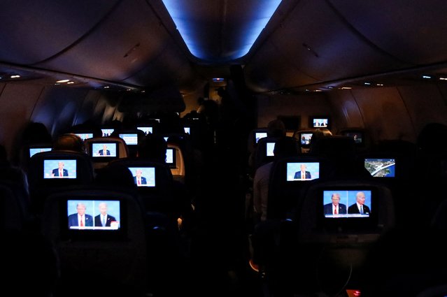 People watch the presidential debate aboard a Delta Airlines flight to Miami, Florida on June 27, 2024. (Photo by Maria Alejandra Cardona/Reuters)