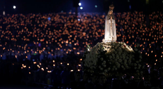 A statue of the Holy Virgin Mary of Fatima is carried during a candlelight vigil, as pilgrims attend the 99th anniversary of the appearance of the Virgin Mary to three shepherd children, at the Catholic shrine of Fatima, Portugal May 12, 2016. (Photo by Rafael Marchante/Reuters)