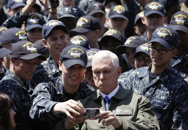 U.S. Vice President Mike Pence, center right at bottom, takes a selfie with U.S. servicemen on the flight deck of U.S. navy nuclear-powered aircraft carrier USS Ronald Reagan, at the U.S. Navy's Yokosuka base in Yokosuka, south of Tokyo, Wednesday, April 19, 2017. (Photo by Eugene Hoshiko/AP Photo)