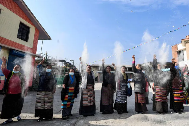 Tibetan exiles throw flour in the air during a ritual marking the 63rd anniversary of the 1959 Tibetan uprising against Chinese rule at Jawalakhel Tibetan camp in Lalitpur on the outskirts of the Kathmandu on March 10, 2022. (Photo by Prakash Mathema/AFP Photo)