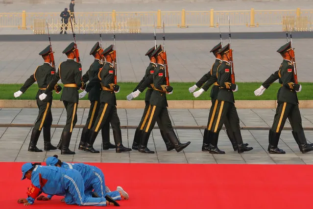 Workers clean a red carpet before a wreath laying ceremony at the Monument to the People's Heroes in Tiananmen Square, marking the 70th anniversary of the founding of the People's Republic of China, in Beijing, China on September 30, 2019. (Photo by Thomas Peter/Reuters)