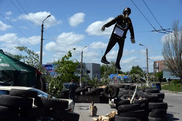 An Effigy depicting a representative of the Kiev authorities is hung over a barricade in the eastern Ukranian city of Slavyansk on May 11, 2014, on the day of the referendum called by pro-Russian rebels in eastern Ukraine to split from the rest of the ex-Soviet republic, in Slavyansk on May 11, 2014. (Photo by Vasily Maximov/AFP Photo)