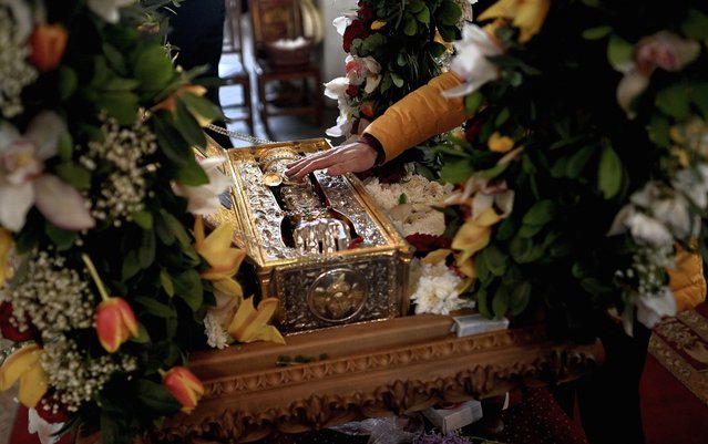 An Orthodox believer touches the relics of Saint George the Great Martyr on display at the church of Saint Sofia in Sofia, Bulgaria, 27 April 2023. A fragment of the right hand of St. Great Martyr George the Victorious, which is kept in the Church of St. George the Victorious, Nigrita, Greece, arrived in Sofia on the eve of the celebration of the great church holiday of St. George in Bulgaria on 06 May. (Photo by Vassil Donev/EPA/EFE)