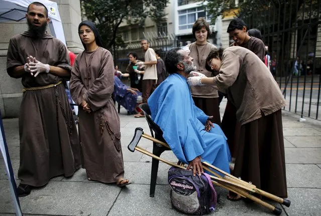 Members of the Franciscan fraternity “O Caminho” (The Way), shave a homeless man in front of Se Cathedral in downtown Sao Paulo July 21, 2015. Sao Paulo, South America's largest city, has an estimated 16,000 homeless people according to the Town hall. “O Caminho” are a group of Franciscan monks and nuns who help the homeless. (Photo by Nacho Doce/Reuters)