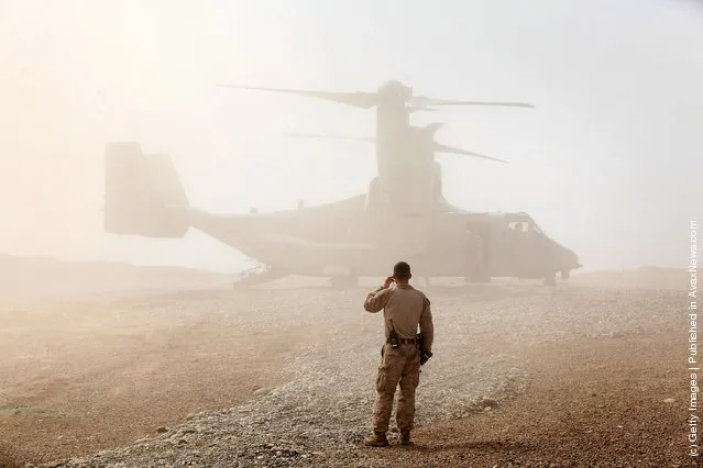 A U.S. Marine watches as an Osprey carrying U.S. Secretary of Defense Leon Panetta arrives March 14, 2012 at Forward Operating Base Shukvani, Afghanistan