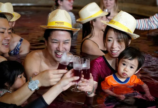 People raise their glasses filled with 2019 Beaujolais Nouveau wine, or grape juice for children, as they bathe in a “wine bath”, colored hot water, on the day of the Beaujolais Nouveau official release, at Hakone Kowakien Yunessun hot spring resort in Hakone, Japan, 21 November 2019. Japan is a major market for the Beaujolais Nouveau and according to local media reports, about 4.5 million bottles of the wine will be imported to Japan by the end of the year. (Photo by Franck Robichon/EPA/EFE)