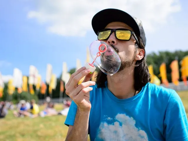 A man blows a bubble as the gates open at the Glastonbury Festival of Music and Performing Arts in Somerset, southwest England, on June 25, 2014. US metal giants Metallica will play this year's coveted Saturday night headline spot at Britain's Glastonbury festival, organisers announced Thursday. It will be the “Master of Puppets” four-piece's first appearance at the legendary festival, held in south west England, following on from The Rolling Stones' Worthy Farm debut last year. (Photo by Leon Neal/AFP Photo)