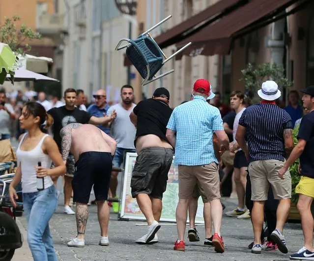 A man throws chair as minor skirmishes continue between soccer fans, in the streets of Marseille, France, ahead of the England vs Russia France Euro 2016 soccer match, Saturday June 11, 2016.  Riot police have thrown tear gas canisters at soccer fans Saturday in Marseille's Old Port in a third straight day of violence in the city. (Photo by Niall Carson/PA Wire via AP Photo)