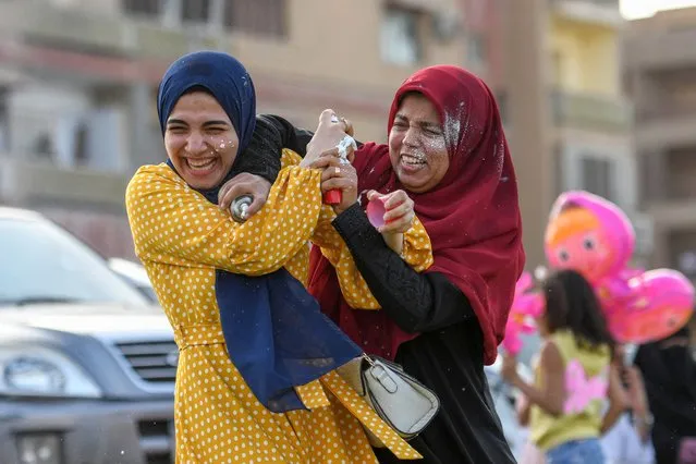 Egyptian Muslim women spray foam on each other after prayers on the first day of Eid al-Fitr, which marks the end of the holy fasting month of Ramadan in the Heliopolis neighbourhood, in the Egyptian capital Cairo, on May 2, 2022. (Photo by Ahmed Hasan/AFP Photo)