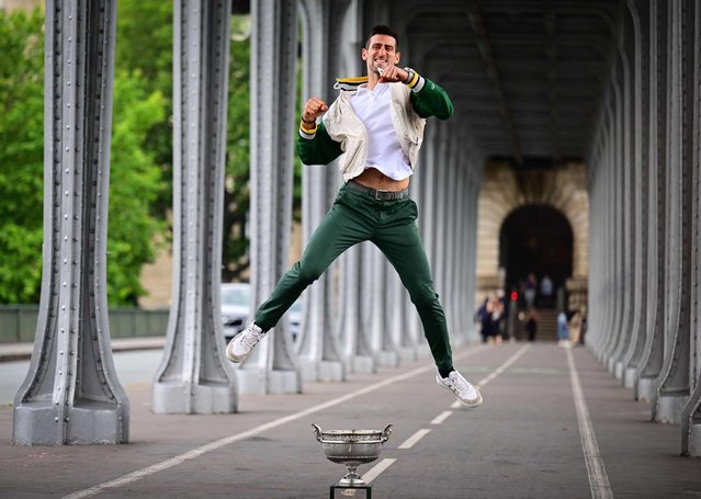 Serbia's Novak Djokovic jumps next to the Musketeers' Trophy during a photocall after winning the Roland-Garros French Open tennis tournament, in Paris, on June 12, 2023. (Photo by Emmanuel Dunand/AFP Photo)