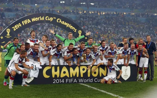 Germany's players pose for pictures as they celebrate with their World Cup trophy after winning their 2014 World Cup final against Argentina at the Maracana stadium in Rio de Janeiro July 13, 2014. (Photo by Michael Dalder/Reuters)