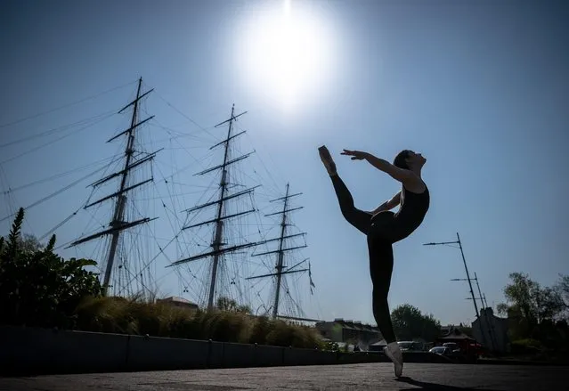 Elizabeth Nicolaou, a final year student with the Royal Academy of Dance, strikes a pose on April 28, 2022 near the Cutty Sark ship in Greenwich, London ahead of International Dance Day. First celebrated in 1982, International Dance Day has taken place every year since in anniversary celebration of the birth of Jean-Georges Noverre (1727-1810), considered the creator of modern ballet. (Photo by Guy Corbishley/Alamy Live News)